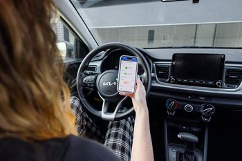 A woman holding a cell phone in a car