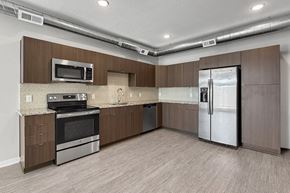 Des Moines apartment for rent - A kitchen with brown cabinets and a stainless steel refrigerator.