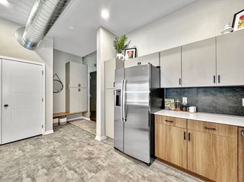 A modern kitchen with a stainless steel refrigerator and wooden cabinets.