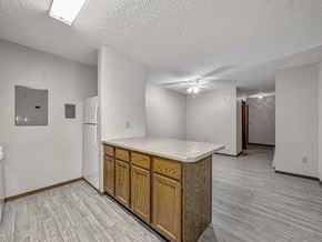 Sioux Falls apartment for rent - an empty kitchen with a counter top and a refrigerator at Creekstone Falls, Sioux Falls, SD, 57106