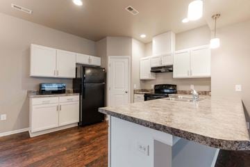 Carlisle apartment for rent - A kitchen with a black refrigerator and white cabinets.