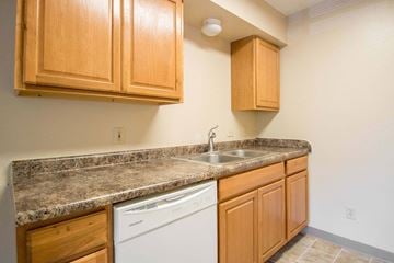 Newton apartment for rent - A kitchen with wooden cabinets and a granite countertop.