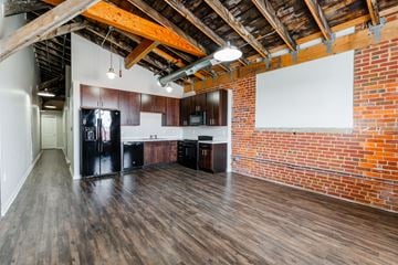 Grinnell apartment for rent - A kitchen area with wooden floors and a brick wall.