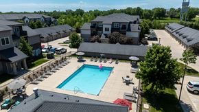 Clive apartment for rent - A large swimming pool surrounded by lounge chairs and umbrellas in a residential area.