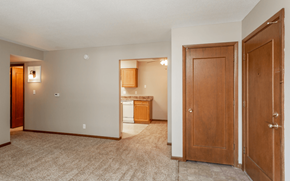 Ankeny apartment for rent - an empty living room and kitchen with a door open to a bedroom at Lake Shore Place Apartments, Ankeny, Iowa
