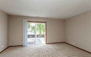 Ankeny apartment for rent - an empty living room with sliding glass doors to a patio at Lake Shore Place Apartments, Ankeny