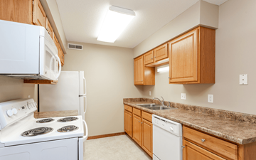Ankeny apartment for rent - A kitchen with a white stove and a white dishwasher.