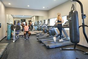 Grimes apartment for rent - A man and a woman are working out in a gym at Meadowlark Place Apartments, Iowa, 50111