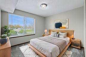 Des Moines apartment for rent - A bedroom with a large bed and a window overlooking a street.