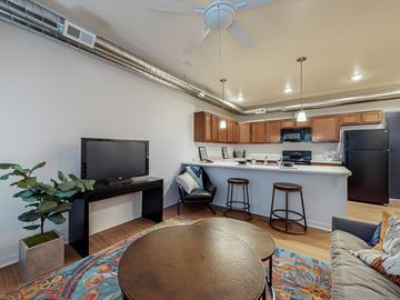Des Moines apartment for rent - A living room with a brown table and a television on a cabinet.