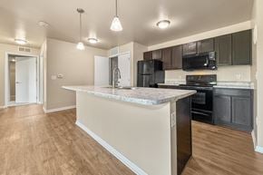 Des Moines apartment for rent - A kitchen with a marble countertop and black appliances at Melbourne Apartments in Des Moines, Iowa 50320.
