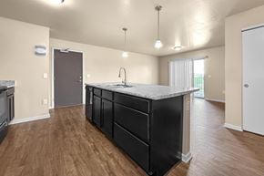 Des Moines apartment for rent - A kitchen at Melbourne Apartments in Des Moines, Iowa 50320 with black cabinets and hardwood flooring.