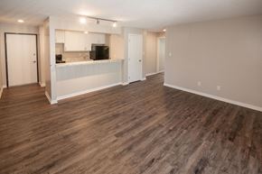 Des Moines apartment for rent - an empty living room and kitchen with a wood floor at Rosemont Place Apartments, Des Moines, IA, 50320