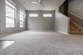 Des Moines apartment for rent - A spacious room with a carpeted floor and a staircase on the right side.