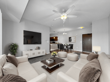 Clive apartment for rent - A modern living room with a white couch and a ceiling fan.