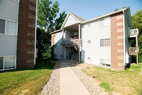 Polk City apartment for rent - A two-story apartment building with a balcony on the second floor. at Saylorville Lakeside, Polk City, Iowa