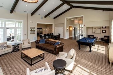 Waukee apartment for rent - A large, well-lit living room with a pool table and comfortable seating.