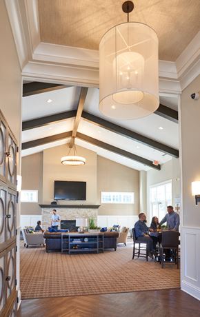 Waukee apartment for rent - a large lobby with people sitting at tables and chairs at The Winhall of Williams Pointe Apartments, Waukee, IOWA