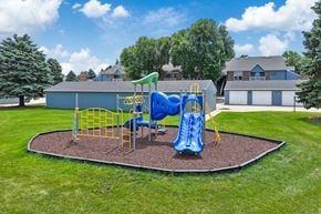Sioux Falls apartment for rent - A playground with a blue slide and yellow safety barriers.