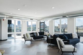 A living room with a black couch and a chair.
