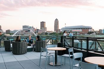 A group of people are sitting on a rooftop terrace.