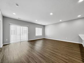 Waukee apartment for rent - an empty living room with wood flooring and a window at Rialto Townhomes Apartments, Waukee