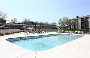 Sioux Falls apartment for rent - a swimming pool with chairs and a fence around it at Penbrooke Place Apartments, Sioux Falls, SD