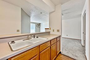 Sioux Falls apartment for rent - A kitchen with wooden cabinets and a white sink at Penbrooke Place Apartments, Sioux Falls