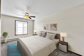 Sioux Falls apartment for rent - A bedroom with a bed, two lamps, a ceiling fan, and a potted plant at Penbrooke Place Apartments, South Dakota, 57106