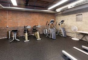 Des Moines apartment for rent - A gym with a brick wall and a variety of exercise equipment.at Riverpoint Lofts, Iowa, 50309