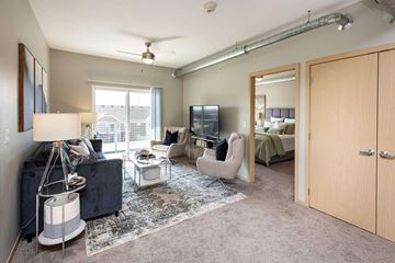 Ankeny apartment for rent - A living room with a black couch and a grey rug.