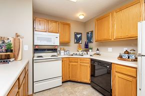 Ankeny apartment for rent - A kitchen with wooden cabinets and white appliances at Lake Shore Park, Ankeny, 50021