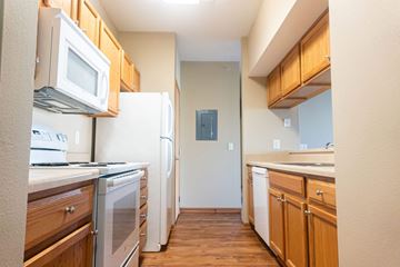 Waukee apartment for rent - A kitchen with wooden cabinets and white appliances.
