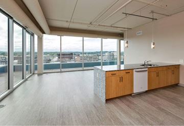 Des Moines apartment for rent - A modern kitchen with wooden cabinets and a large window overlooking the city.