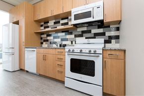 Des Moines apartment for rent - A kitchen with white appliances and wooden cabinets.at City Square Lofts, Des Moines, 50309  