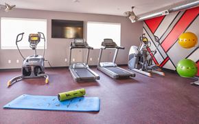 Des Moines apartment for rent - a gym with exercise equipment and weights on the floor at Vue Apartments, Des Moines, Iowa