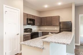 Altoona apartment for rent - a kitchen with granite counter tops and black appliances at The Barclay Apartments, IOWA