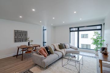 Des Moines apartment for rent - A modern living room with a grey sofa and a glass coffee table.