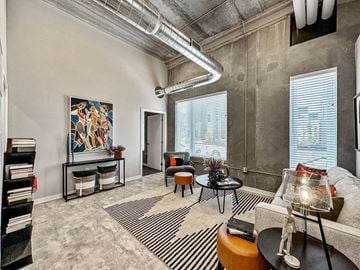 Des Moines apartment for rent - A living room with a large painting on the wall and a striped rug on the floor.