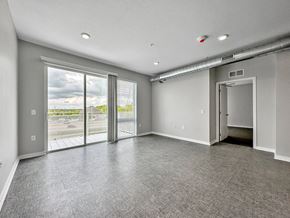 Des Moines apartment for rent - A spacious room with grey carpeting and a view of the outdoors through large windows.at Level, Des Moines Iowa   