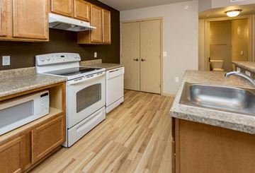 Norwalk apartment for rent - A kitchen with wooden cabinets and a white stove top oven.