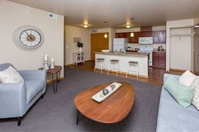 Des Moines apartment for rent - a living room with a couch and a table in front of a kitchen at Melbourne Apartments, Des Moines, IA,  50320