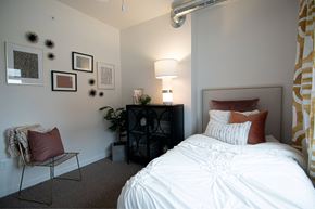 Des Moines apartment for rent - a bedroom with a bed and a lamp and pictures on the wall at Melbourne Apartments, Des Moines, Iowa