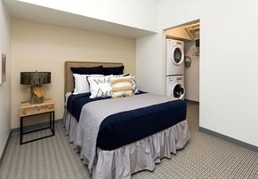 Des Moines apartment for rent - a bedroom with a bed and a washing machine at Eagle View Lofts, Iowa