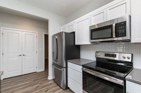West Des Moines apartment for rent - A kitchen with black appliances and white cabinets. at Two Rivers Home Rentals, West Des Moines, IA