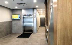 Waterloo apartment for rent - A hallway with a black mat on the floor and a TV mounted on the wall.