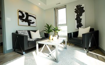 Waterloo apartment for rent - A living room with a black couch, a white coffee table, and a large abstract painting on the wall.