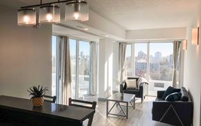 Waterloo apartment for rent - A living room with a view of the city through large windows.