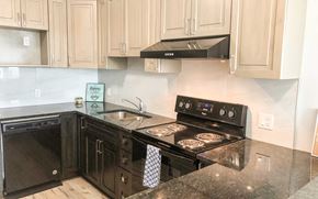 Waterloo apartment for rent - A kitchen with black appliances and wooden cabinets.