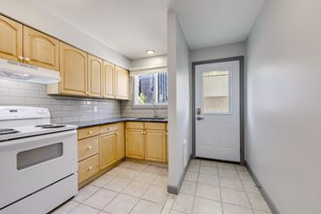 Waterloo apartment for rent - A kitchen with wooden cabinets and a white stove top oven.